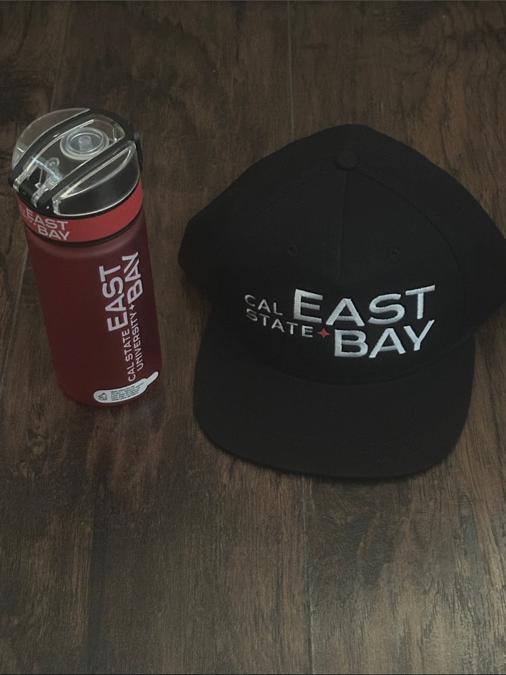 Cal State East Bay Black Snapback Hat and Red Water Bottle
